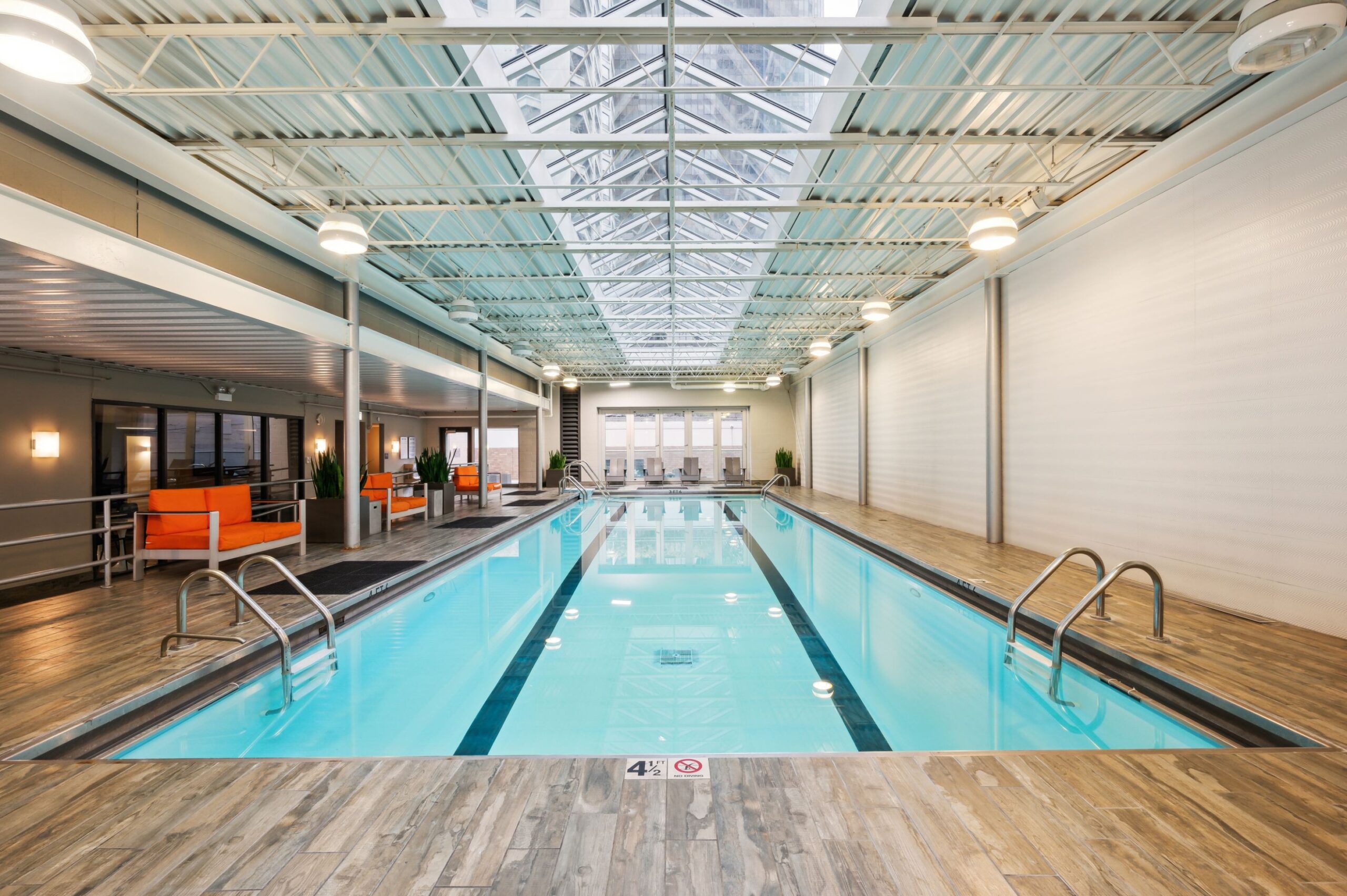 Expansive indoor pool with bright lounge seating at ReNew Waterside